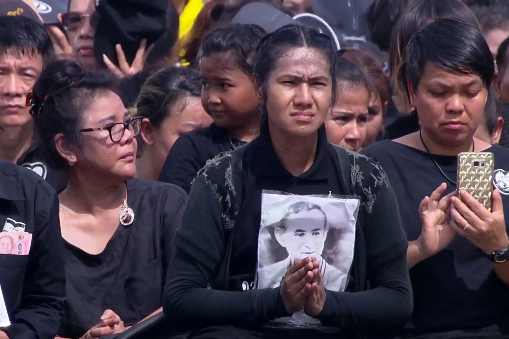 泰國王家喪禮移靈儀式的上午天氣炎熱　許多民眾仍耐心跪坐在馬路旁