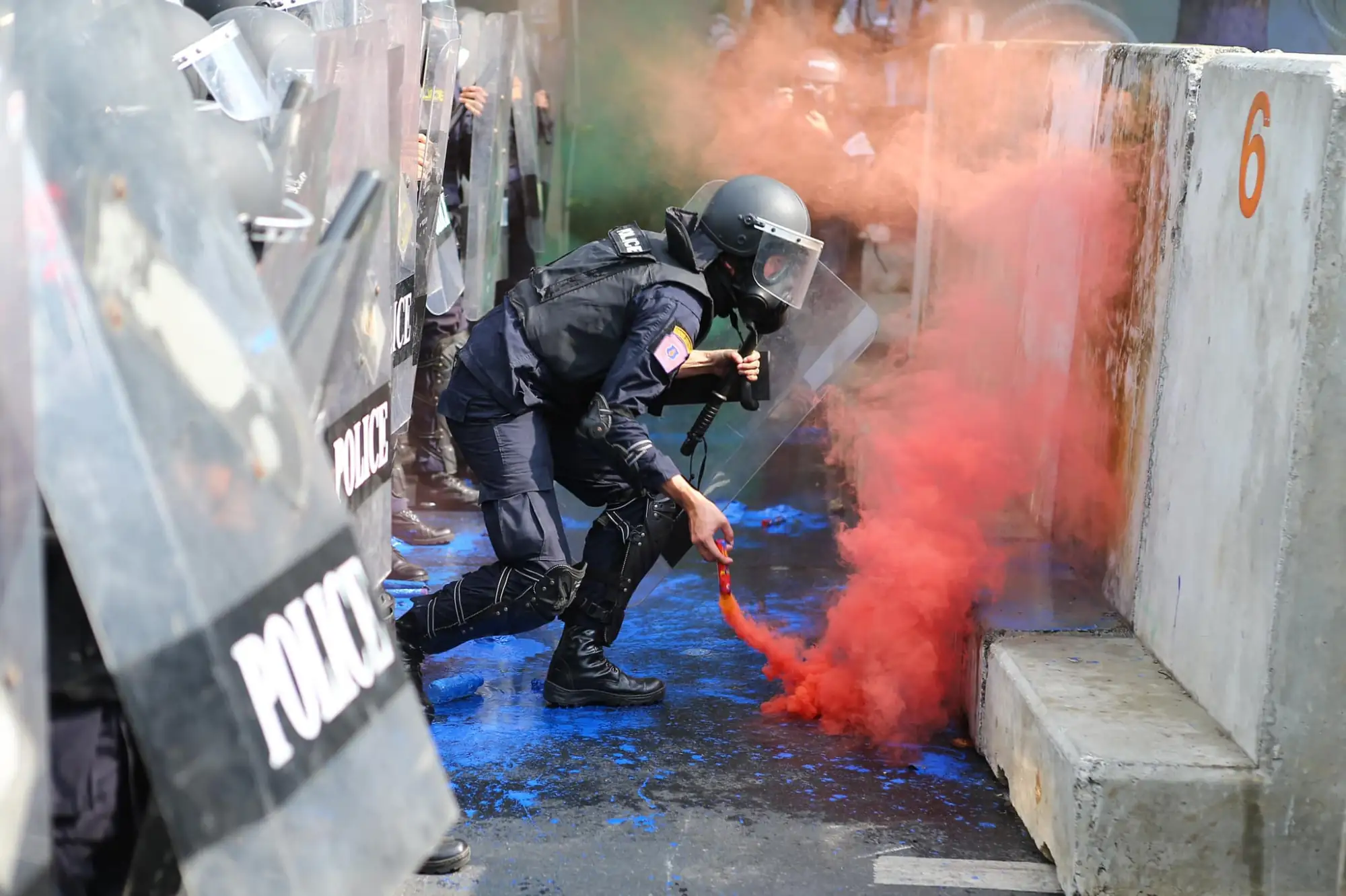 泰国示威群众朝警方丢烟雾弹与油漆袋，企图突破封锁线（图片来源：Free YOUTH)）