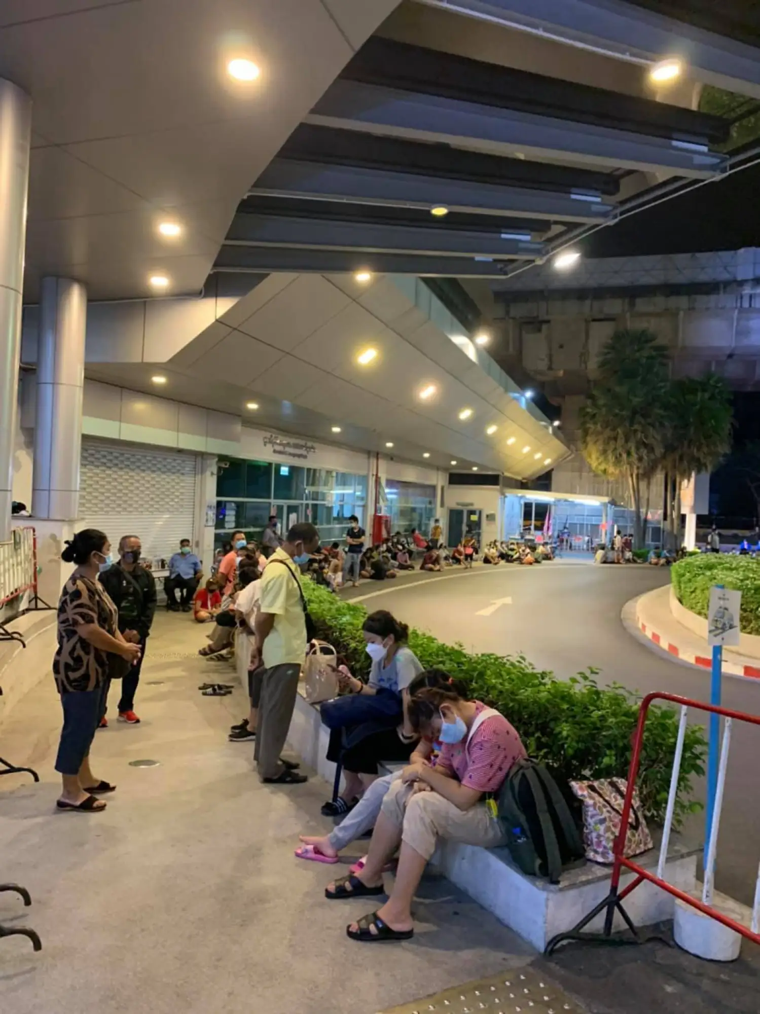拉瑪提波迪醫院(Ramathibodi Hospital)外可見數十名戴著口罩的民眾，坐在醫院外漏夜等候床位(圖片來源：FB@thiravat.h)