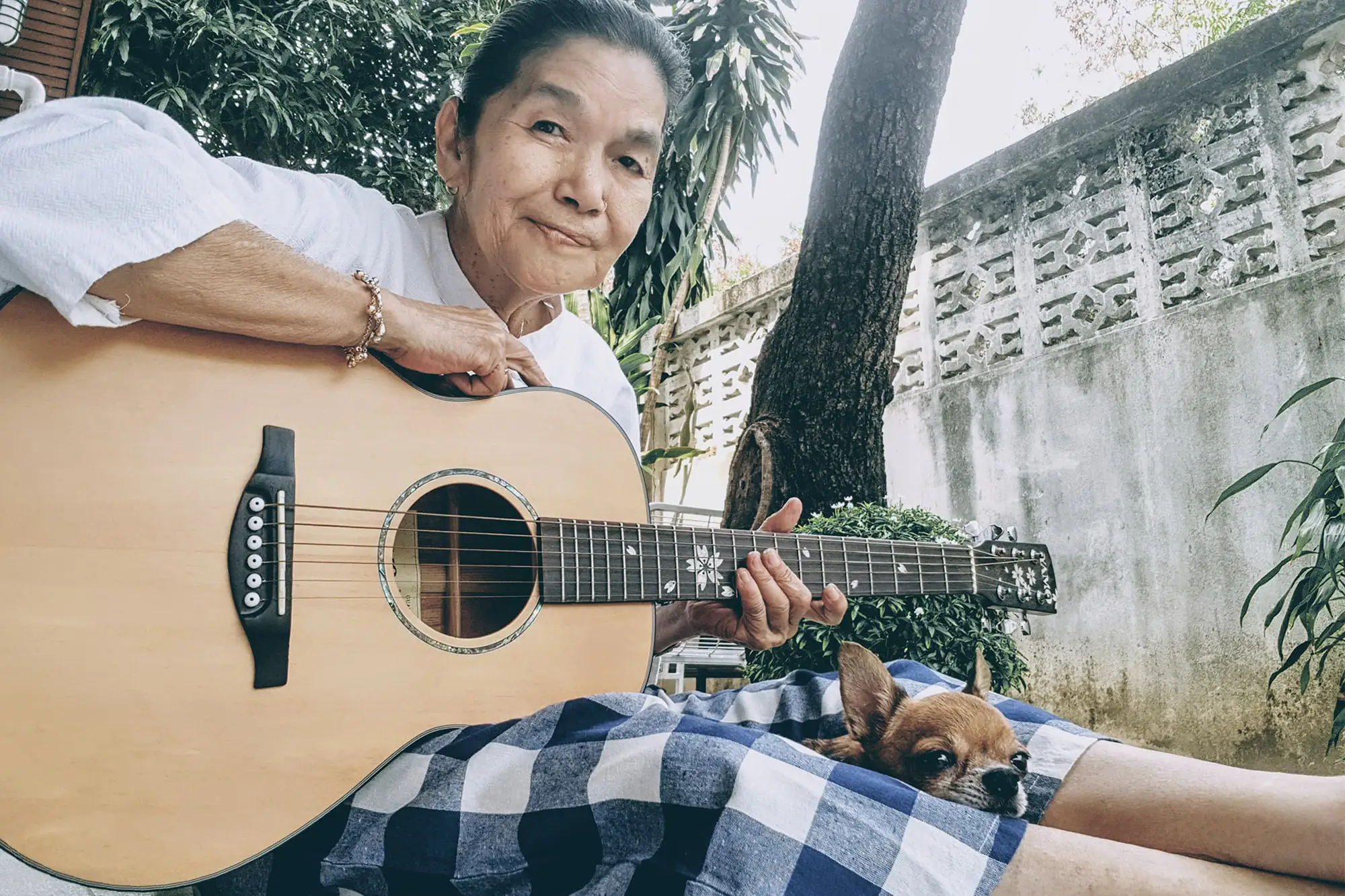 一把吉他，幾只小狗，泰國網紅瑪琳達奶奶的晚年生活太療癒了！（圖片來源：FB@หญิงชรา กะ หมาน้อย）