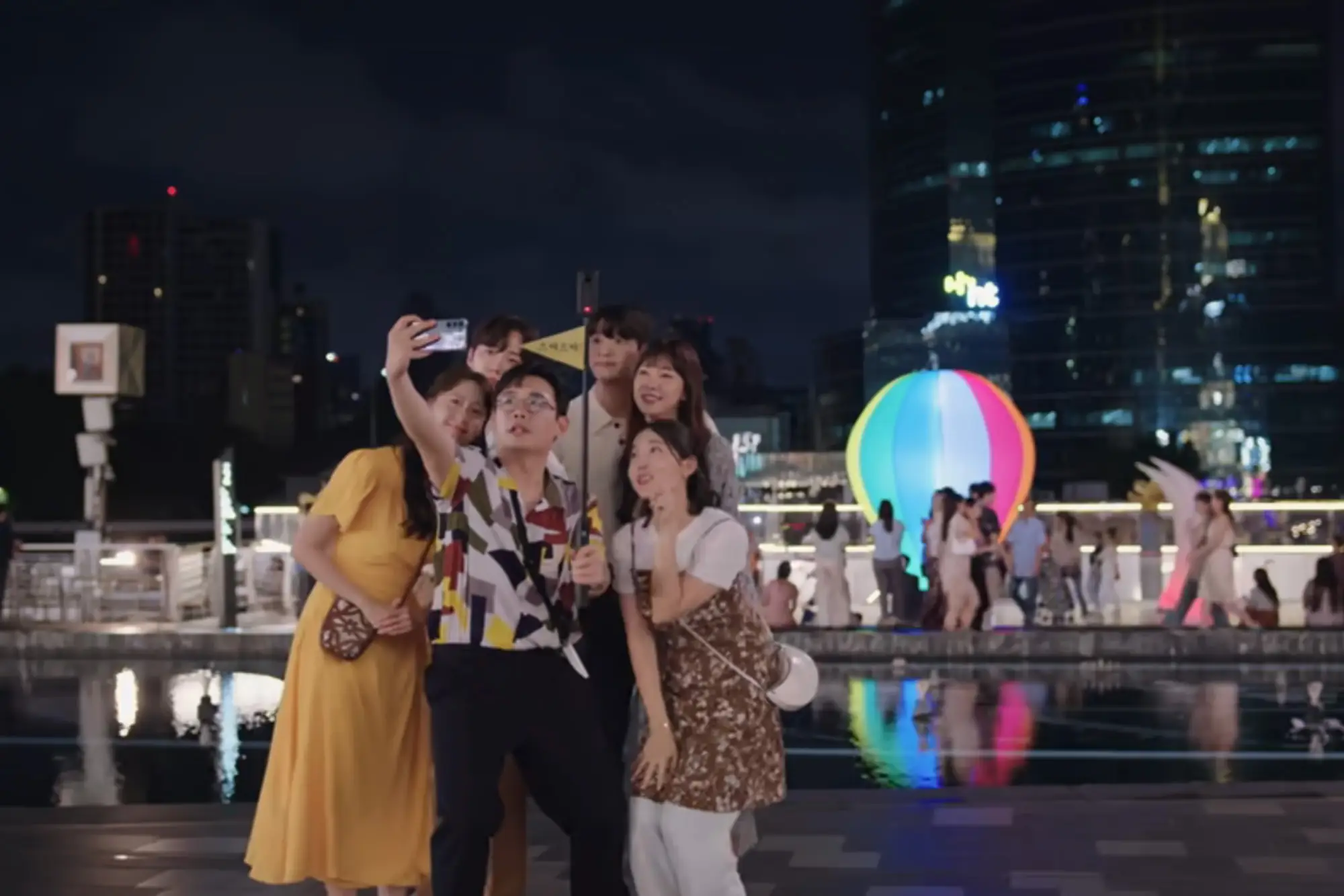 一行人在「曼谷暹罗天地ICONSIAM」多彩的声光水影秀下打闹（图片来源：Netflix）