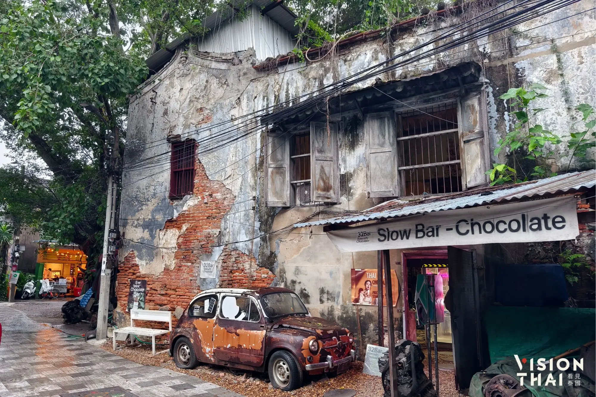 32 BAR 咖啡店的标志一辆小旧车停靠在古老建筑的砖墙边（看见泰国 VIsion Thai）