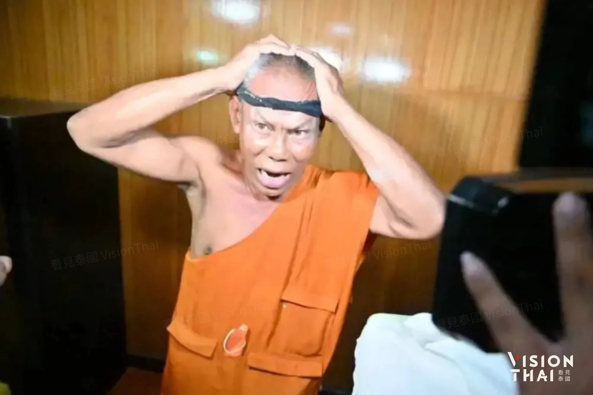 2022年前住持帕薩通蓬「頭痛髮圈」梗爆紅，樓梯下藏中年女性。（圖片來源：NATION）